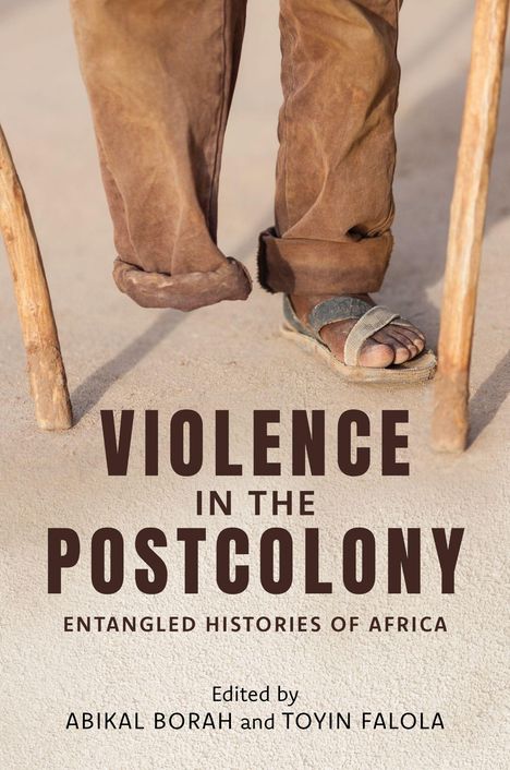 „VIOLENCE IN THE POSTCOLONY: ENTANGLED HISTORIES OF AFRICA“. Zwei Beine in braunen Hosen und Sandalen, zwei Holzstöcke.