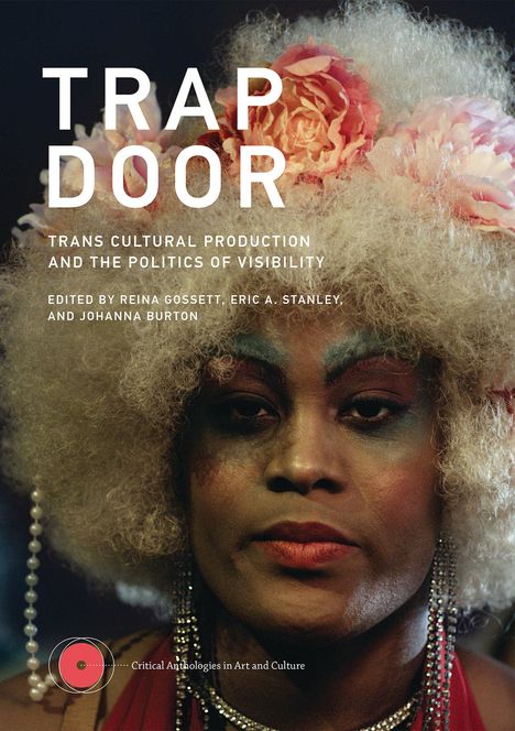 "TRAP DOOR: Trans Cultural Production and the Politics of Visibility." Eine Person mit Blumen im Haar und auffälligem Make-up.