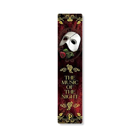 „THE MUSIC OF THE NIGHT“; weiße Maske und rote Rose auf verzierter, dunkler Oberfläche; goldene Verzierungen.