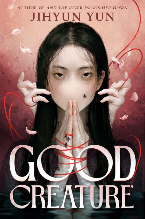 "Jihyun Yun. Good Creature." Eine Frau mit abgedecktem Gesicht und Fliegen, Hände mit roten Fäden umschlungen.