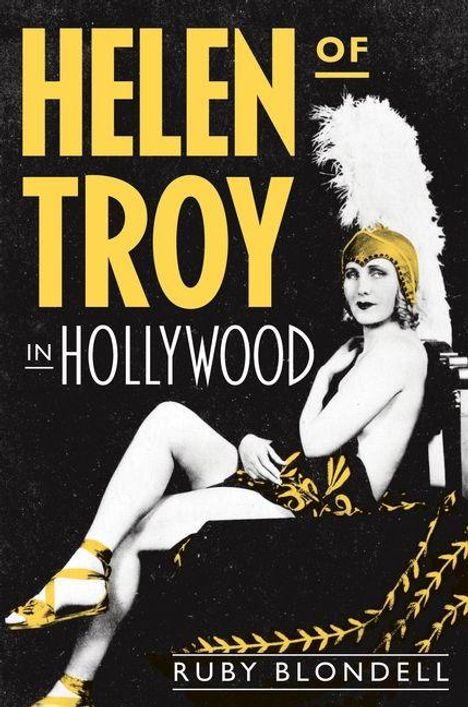 „Helen of Troy in Hollywood“ von Ruby Blondell. Frau in glamourösem Kostüm mit Federkopfschmuck vor schwarzem Hintergrund.
