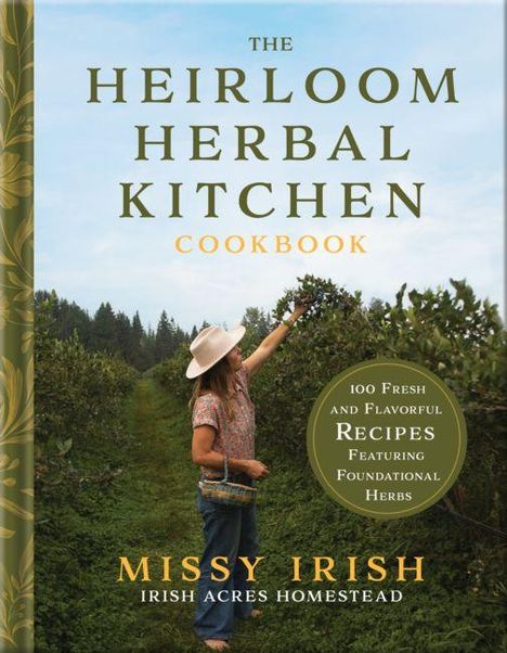 Titel: "The Heirloom Herbal Kitchen Cookbook". Frau pflückt im Garten Kräuter. Links ein goldener Buchrücken.