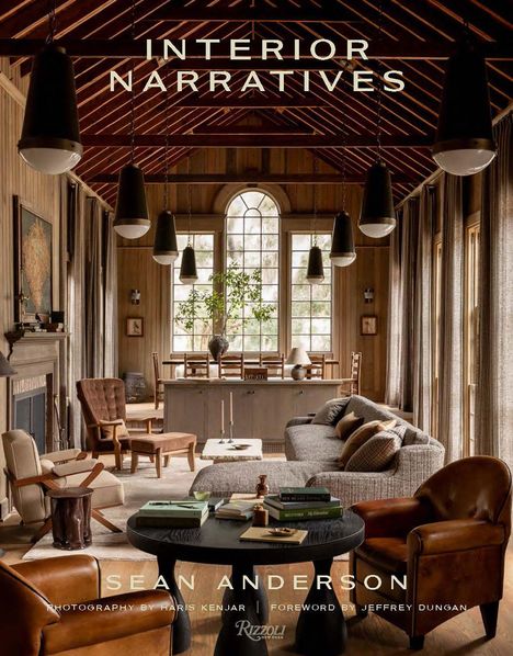 "INTERIOR NARRATIVES" und "SEAN ANDERSON" stehen im Raum. Ein gemütliches Wohnzimmer mit Holzwänden, Sofas und Sesseln.