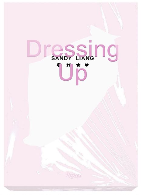 "Dressing Up SANDY LIANG" in großen, rosa und schwarzen Buchstaben. Weiße und rosa geometrische Muster im Hintergrund.