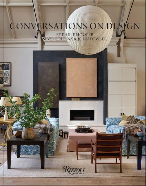 "Conversations on Design" von Philip Hooper. Zwei Sessel mit blauen Mustern, Kamin, runder Papierlampion, Zimmerpflanzen.