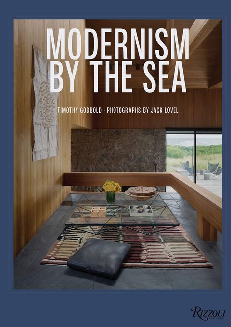 "MODERNISM BY THE SEA" steht in einem modern eingerichteten Raum mit hölzernen Wänden und Steinboden.