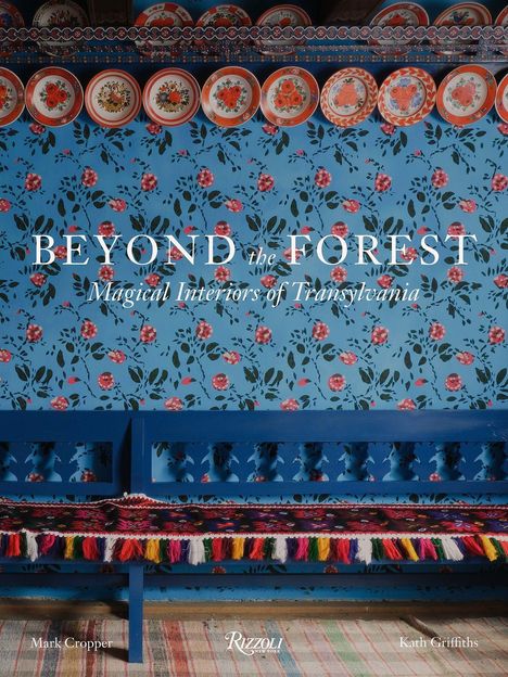 Text: "BEYOND the FOREST: Magical Interiors of Transylvania." Bunte bemalte Teller auf blumiger Wand, blaue Bank.