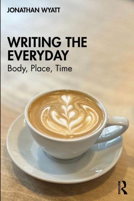 "WRITING THE EVERYDAY: Body, Place, Time" von Jonathan Wyatt. Eine Tasse Kaffee mit Latte Art in einem Café.