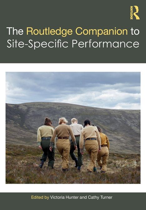 "The Routledge Companion to Site-Specific Performance." Fünf Personen wandern in beiger und grüner Kleidung durch eine hügelige Landschaft.