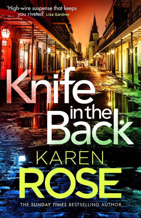"Knife in the Back" und "Karen Rose" text in bunter Schrift, beleuchtete Stadtansicht bei Nacht in warmem Licht.