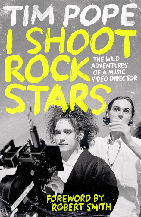 Text: "Tim Pope: I Shoot Rock Stars. The Wild Adventures of a Music Video Director. Foreword by Robert Smith."  
Schwarz-weißes Foto von zwei Personen, eine Person mit Kamera.