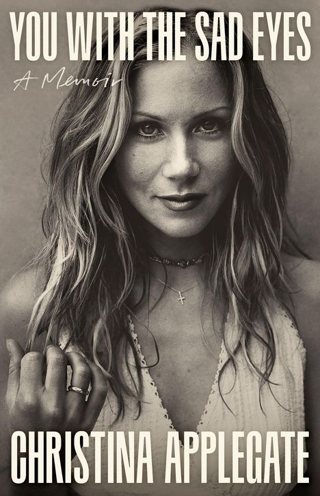 „YOU WITH THE SAD EYES“ und „CHRISTINA APPLEGATE“. Porträt einer Frau mit langen Haaren und Schmuck.