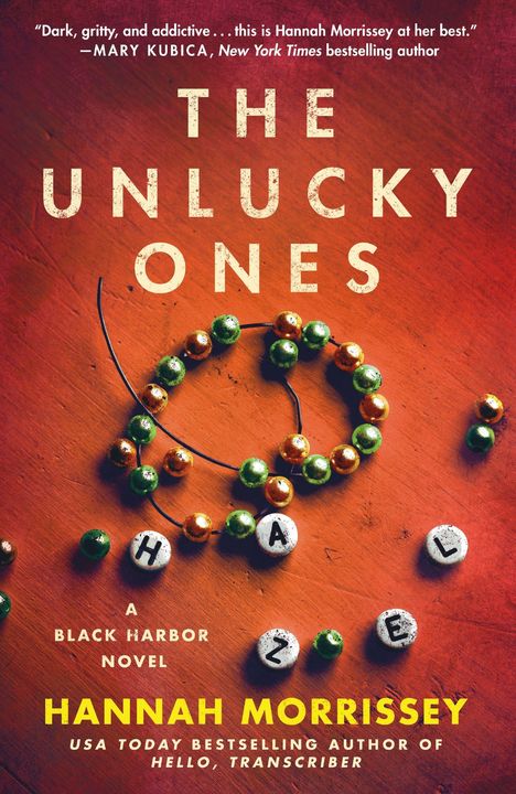 Text: "THE UNLUCKY ONES," "HAZEL," "A BLACK HARBOR NOVEL," "HANNAH MORRISSEY." Perlenarmband auf Holzoberfläche.