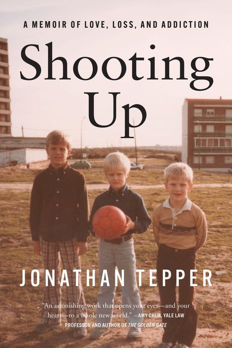 "Shooting Up" von Jonathan Tepper. Drei Jungen stehen draußen, einer hält einen roten Fußball.