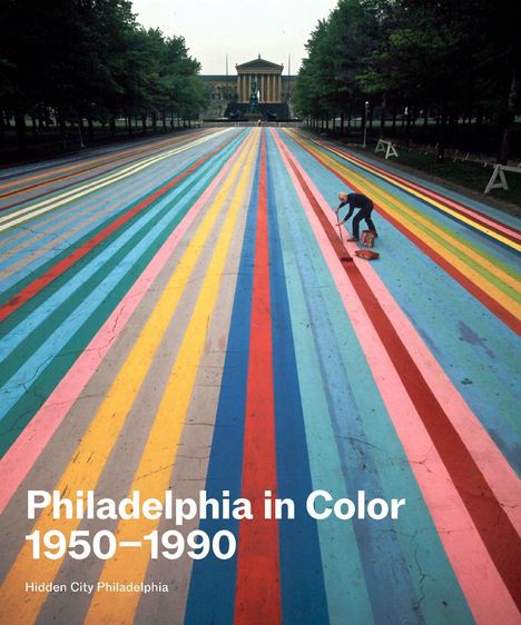 „Philadelphia in Color 1950–1990“ steht in weißer Schrift. Ein Mann bemalt mit Streifen in verschiedenen Farben eine Straße.