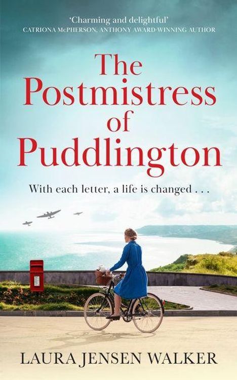 „The Postmistress of Puddlington“ steht in roter Schrift. Eine Frau in Blau fährt Fahrrad entlang der Küste.