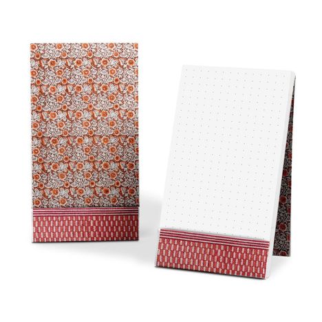 Zwei aufklappbare Notizbücher, das Eine mit floralen Mustern, das Andere mit gepunktetem Papier, beide mit rotem Rand.