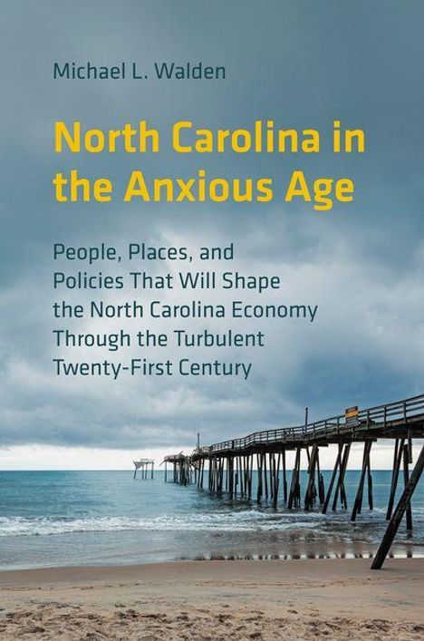 Text: "North Carolina in the Anxious Age" von Michael L. Walden. Bild eines Stegs, der ins Meer führt, unter bewölktem Himmel.