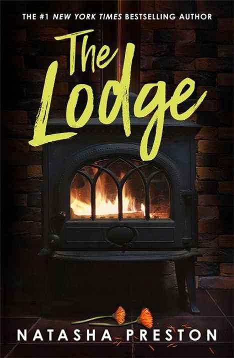 "The Lodge" von Natasha Preston. Ein brennender Kamin vor einer Ziegelwand. Unten liegen zwei orangefarbene Federn.