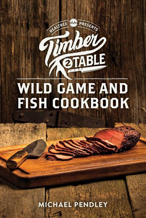 "REALTREE PRESENTS Timber 2 Table Wild Game and Fish Cookbook. Michael Pendley." Holzbrett mit geschnittenem Fleisch und Messer.