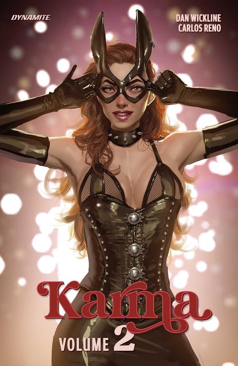 „Karma Volume 2“. Frau in Lederoutfit und Maske, posiert selbstbewusst vor einem unscharfen, glänzenden Hintergrund.