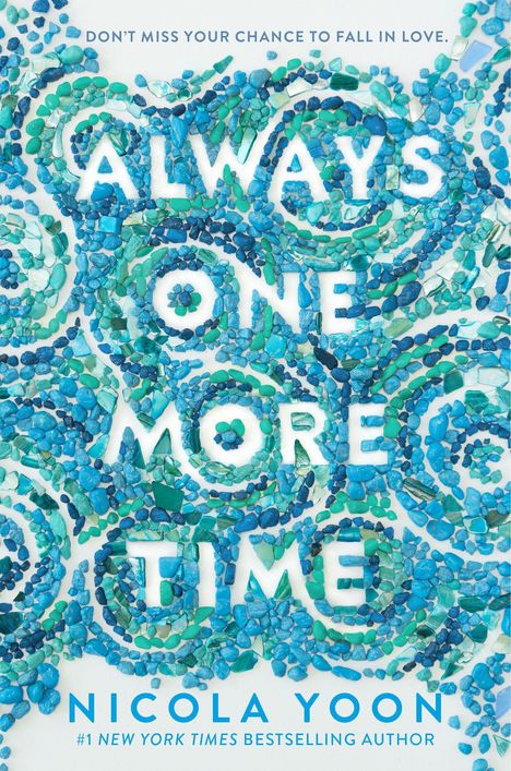 "ALWAYS ONE MORE TIME" aus blauen und grünen Steinen, Name "NICOLA YOON" unten. Verspieltes Design aus bunten Steinen.