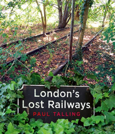 Schild mit Text: "London's Lost Railways, Paul Talling". Alte Bahngleise im Wald, umgeben von Bäumen und Efeu.
