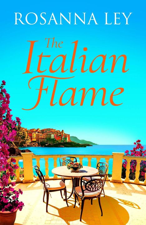 "Rosanna Ley, The Italian Flame." Eine Terrasse mit Tisch und Stühlen, Blick auf Küste und Meer, bunte Häuser im Hintergrund.