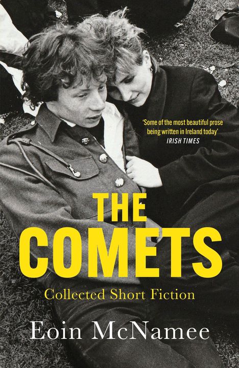 Text: "The Comets. Collected Short Fiction. Eoin McNamee." Ein schwarz-weißes Foto von zwei Personen, die auf Gras liegen.