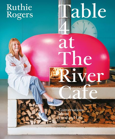 Text: "Ruthie Rogers. Table 4 at The River Cafe. Conversations about Food and Life." Frau sitzt lächelnd auf Holztisch vor Ofen.