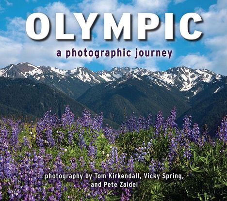 „OLYMPIC“ und „a photographic journey“. Im Vordergrund blühende violette Blumen, dahinter schneebedeckte Berge und blauer Himmel.