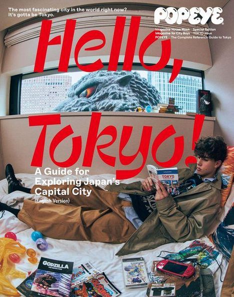 "Hello, Tokyo! A Guide for Exploring Japan's Capital City" in großen roten Buchstaben. Junge liest im Raum, Godzilla draußen.