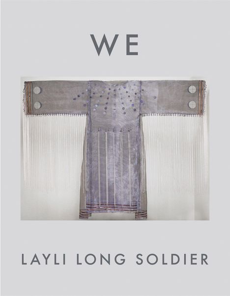 Oben steht "WE", unten "LAYLI LONG SOLDIER". In der Mitte ist ein kunstvolles Gewand mit langen Fransen abgebildet.