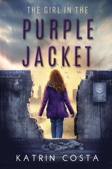 „THE GIRL IN THE PURPLE JACKET“, „KATRIN COSTA“. Ein Mädchen in lila Jacke steht vor einer kaputten Mauer mit Stadtblick.