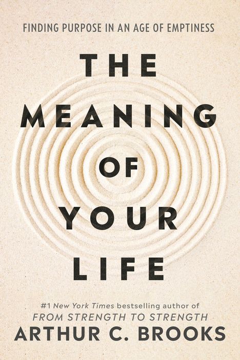Texte: "The Meaning of Your Life", "Arthur C. Brooks". Sand mit konzentrischen Kreisen im Hintergrund.