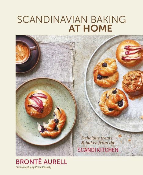 SCANDINAVIAN BAKING AT HOME. Brontë Aurell. Gebäckstücke auf Tellern und eine Tasse Kaffee auf einem Tuch.
