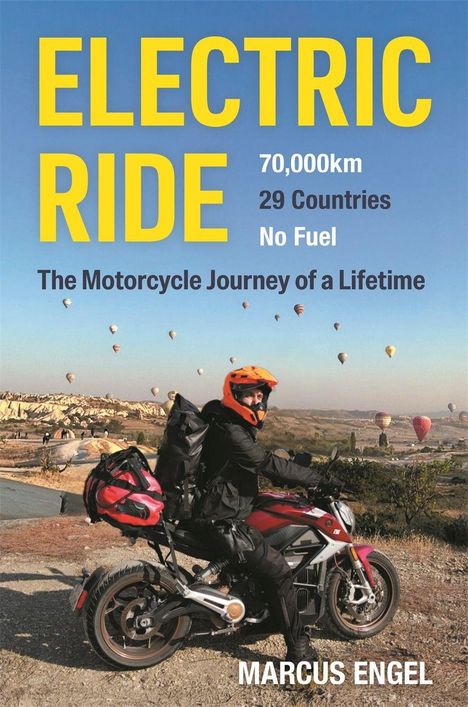 "ELECTRIC RIDE: 70,000km, 29 Countries, No Fuel. A motorcyclist mit rotem Helm vor Ballons am Himmel."