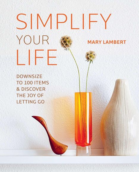 "Simplify Your Life. Mary Lambert. Downsize to 100 items & discover the joy of letting go." Weiße Vase, orange Vase, Holzfigur.