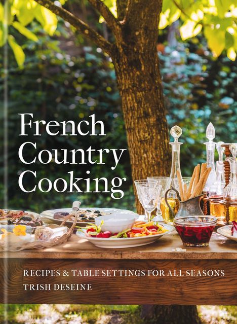„French Country Cooking“; unten: „Recipes & Table Settings for All Seasons, Trish Deseine“. Ein gedeckter Tisch im Freien.