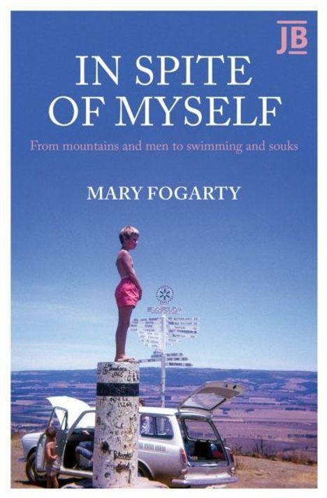 „IN SPITE OF MYSELF“; Untertitel: „From mountains and men to swimming and souks“; Autor: „MARY FOGARTY“. Junge steht auf einem Pfeiler neben einem Auto, weite Landschaft im Hintergrund.