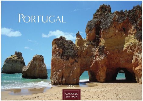 "Portugal. 2027. CASAES EDITION." Felsformationen am Strand unter einem blauen Himmel mit Wolken.