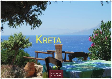 Text: "KRETA", "2027", "CASARES EDITION". 

Harmonie aus blauem Meer, grünen Pflanzen und einem Tisch mit bunner Decke.