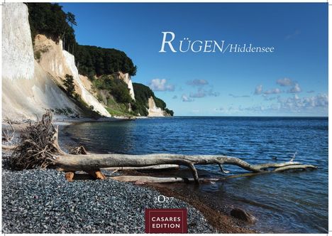 Rügen/Hiddensee. Casares Edition. Ein Strand mit Kreidefelsen, blauem Meer und einem Baumstamm im Vordergrund.