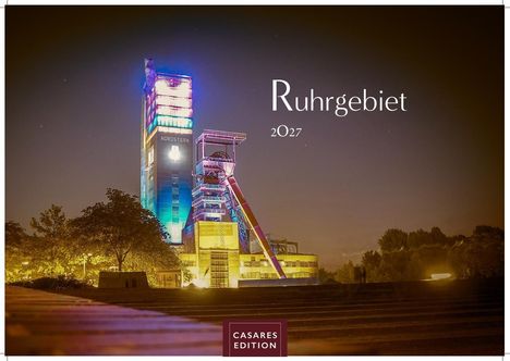 "Ruhrgebiet 2027." Ein beleuchteter industrieller Turm, umgeben von Bäumen und einem ruhigen, dunklen Himmel.