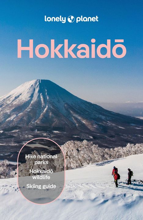 "Hike national parks, Hokkaidō wildlife, Skiing guide." Zwei Wanderer vor verschneitem Berg unter blauem Himmel.