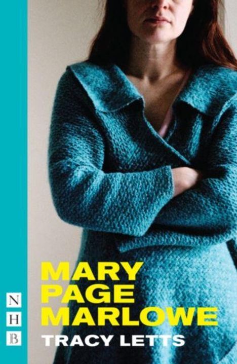 „MARY PAGE MARLOWE“ von Tracy Letts. Frau in blauem Mantel mit verschränkten Armen, neutrales Gesicht.