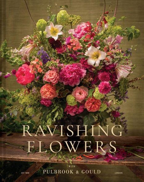 "Ravishing Flowers" mit üppigem Blumenarrangement in kräftigen Farben, darunter Lilien und Rosen, auf rustikalem Tisch.