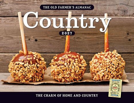 "The Old Farmer’s Almanac Country 2027". Drei Karamelläpfel mit Nüssen auf Holzbrett. Darunter kleines Buchcover.