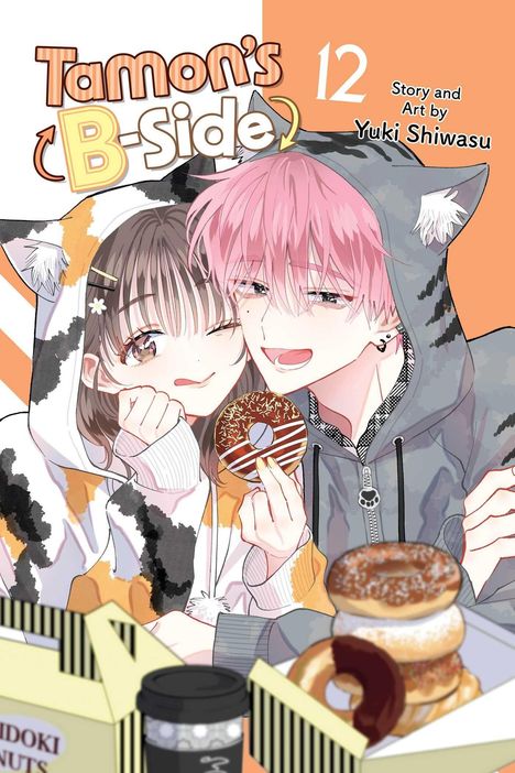 Titel: „Tamon’s B-Side 12“. Zwei Figuren in Kapuzenjacken; er hält einen Donut. Illustration mit Donuts im Vordergrund.