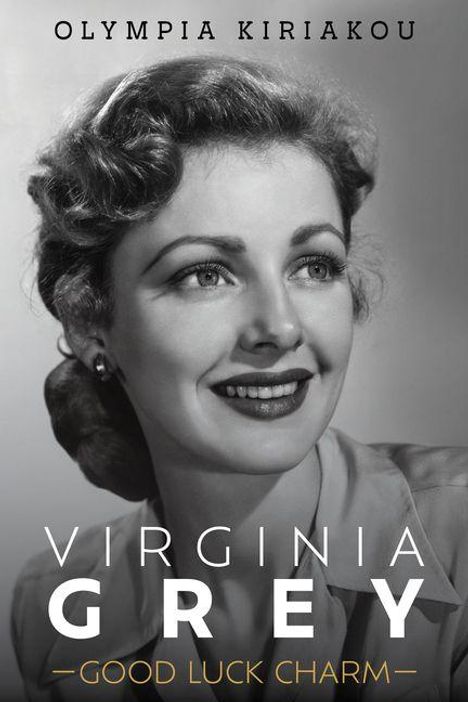 Große Schrift: "Virginia Grey - Good Luck Charm". Oben: "Olympia Kiriakou". Schwarz-weißes Porträt einer Frau.
